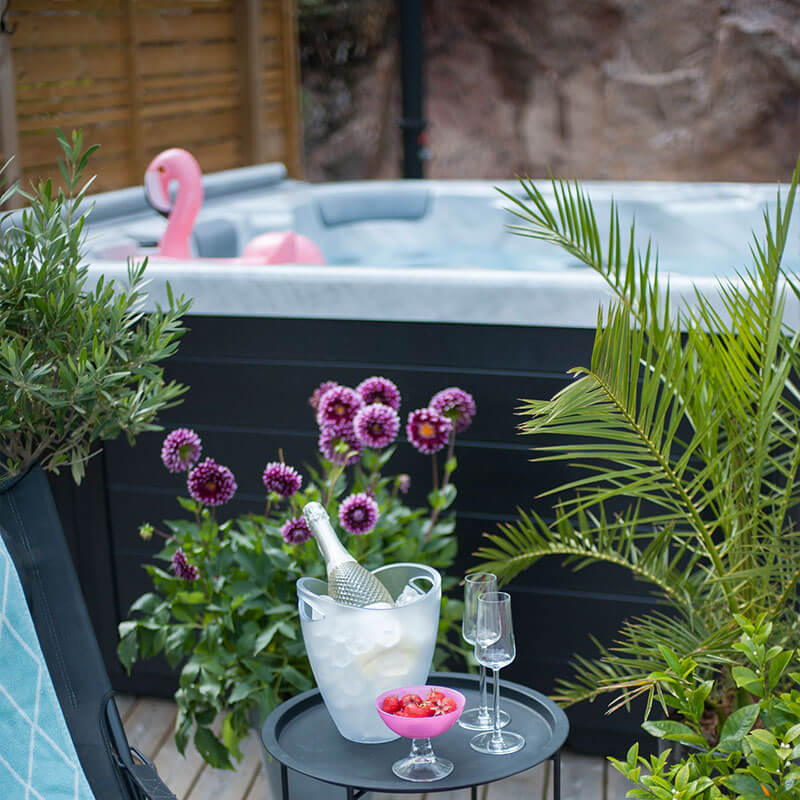 Terrasse avec un spa et un seau de champagne en premier plan
