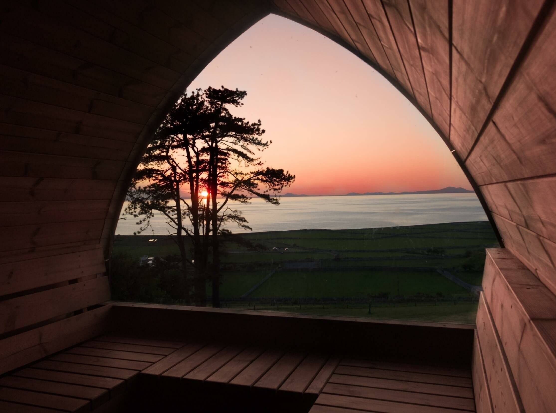Vue sur la mer et le soleil couchant depuis l'intérieur du sauna extérieur Igloo vendu par Aqua éruptions